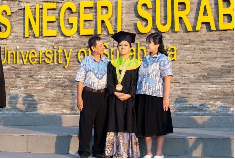 Syema Gloria bersama kedua orang tua di lapangan Rektorat Unesa, sebelum prosesi wisuda.