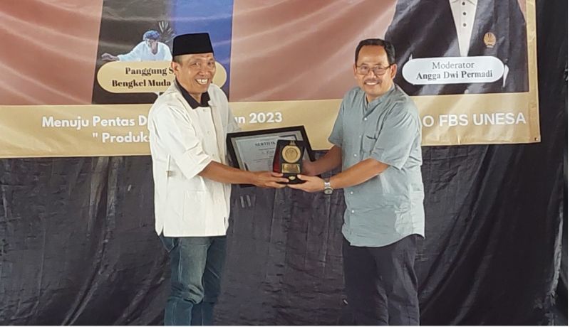 Koorprodi S-1 Sastra Indonesia (kanan) menyerahkan piagam dan cinderamata kepada Achmad Zaenuri sebagai pemateri Kuliah Tamu dan Bedah Buku tersebut.