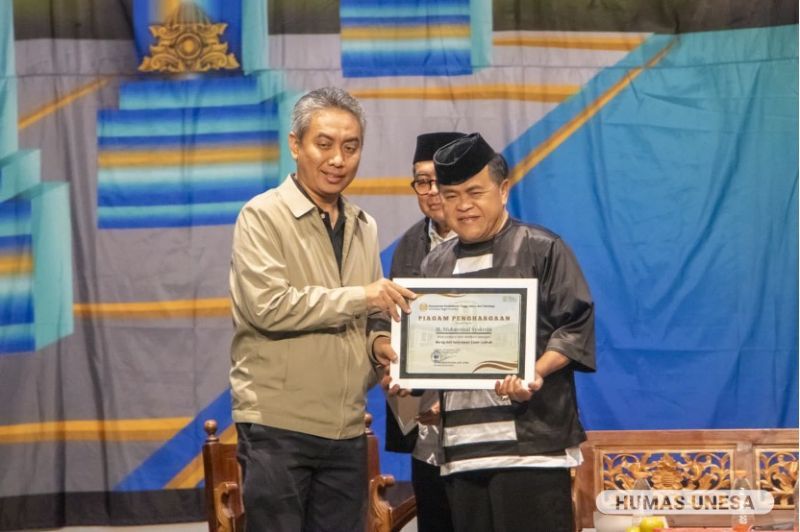 Dekan FBS, Syafi\'ul Anam memberikan penghargaan kepada narasumber, Abah Kirun